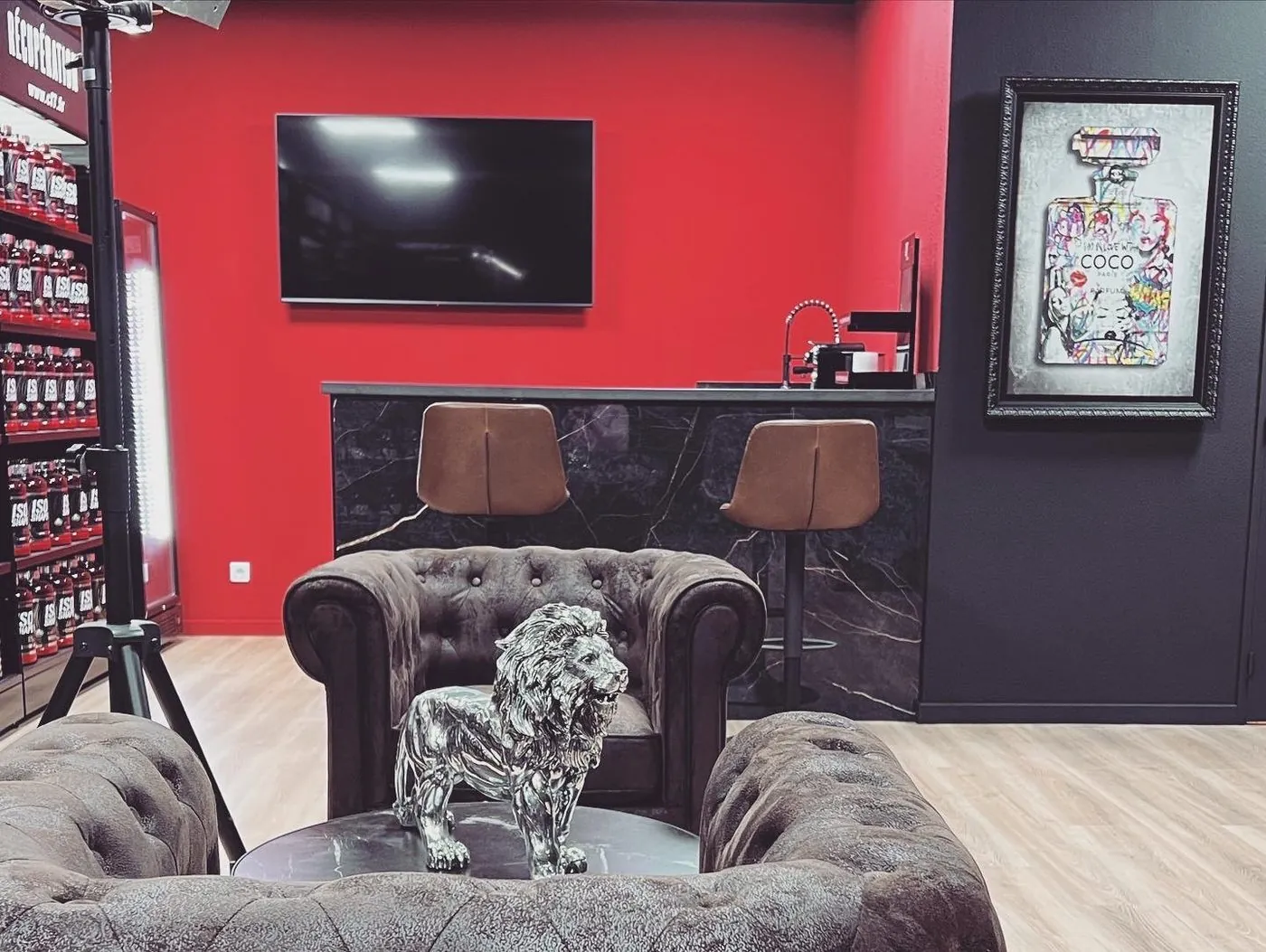 L’accueil d’un centre CF7 : mur rouge, fauteuils Chesterfield, lion argenté et rayons de compléments.